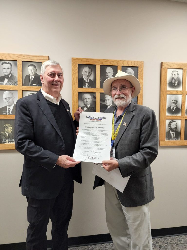 Board Member Jim Martin presents the Stars and Stripes Proclamation for Independence, Missouri to Mayor Rory Rowland