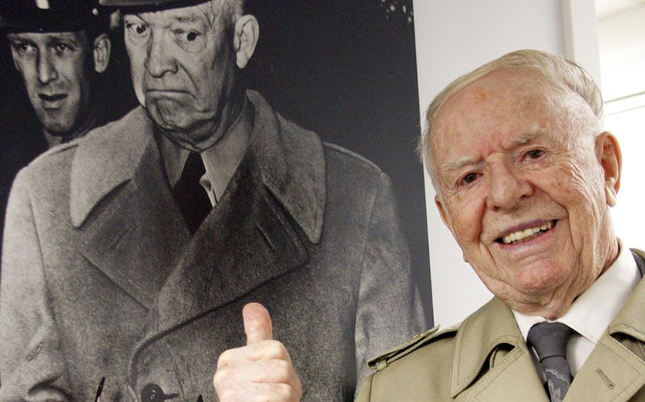 Longtime Stars and Stripes photographer Red Grandy poses next to a photograph he took of General Dwight Eisenhower Photo Credit Stars and Stripes