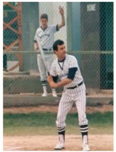 Ronald Hatcher in a baseball uniform on a field, holding a bat and ready to swing during a game in Japan.